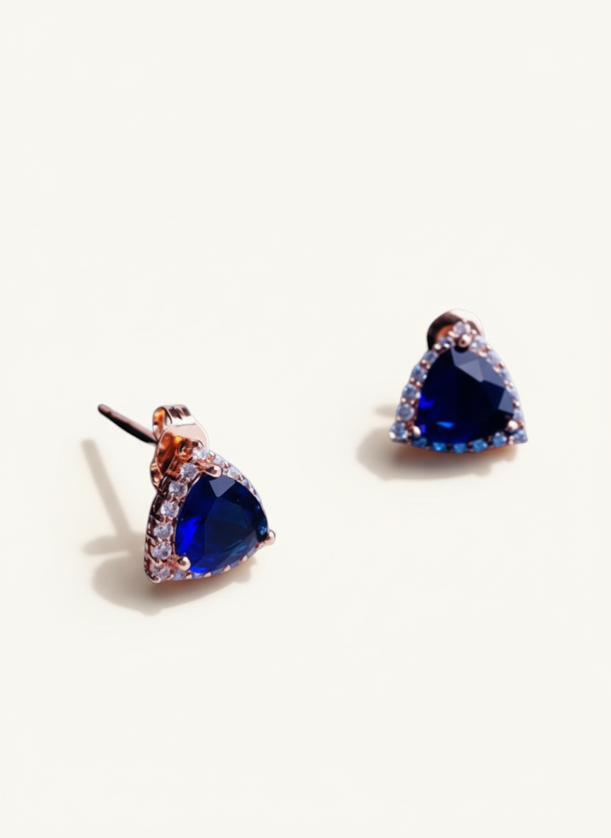 Luxiage gold-tone triangle earrings with deep blue crystals and clear accent stones. Modern geometric design.