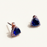 Luxiage gold-tone triangle earrings with deep blue crystals and clear accent stones. Modern geometric design.